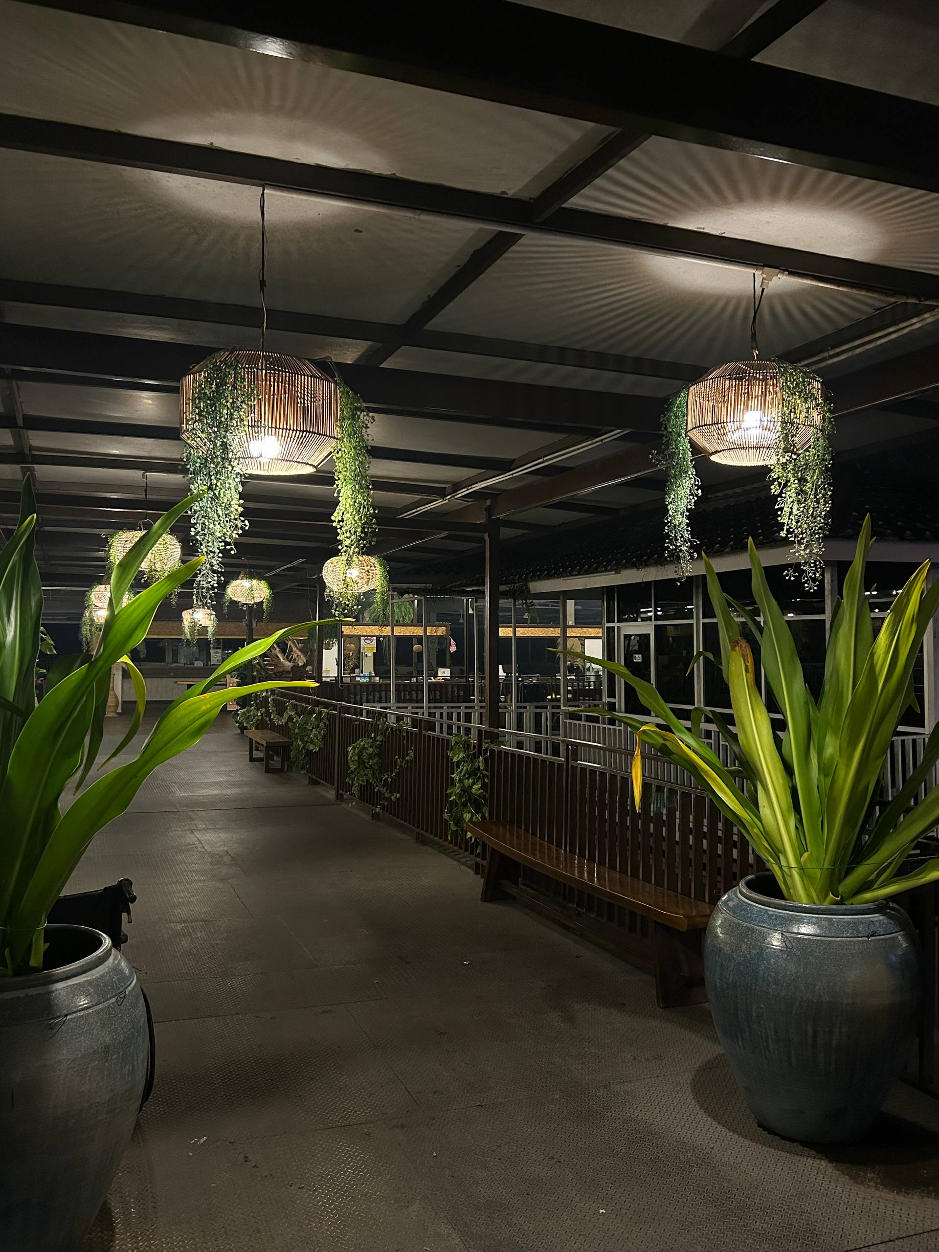 The walkway into Araso lined with green plants and glowing woven lanterns